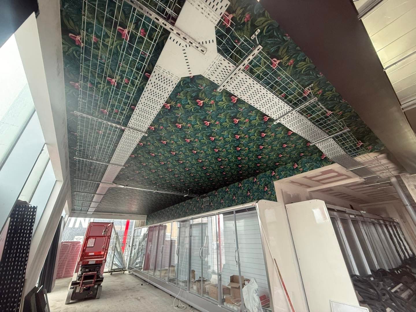 Cable containment and wire basket tray installed across a commercial retail unit ceiling during a fit-out