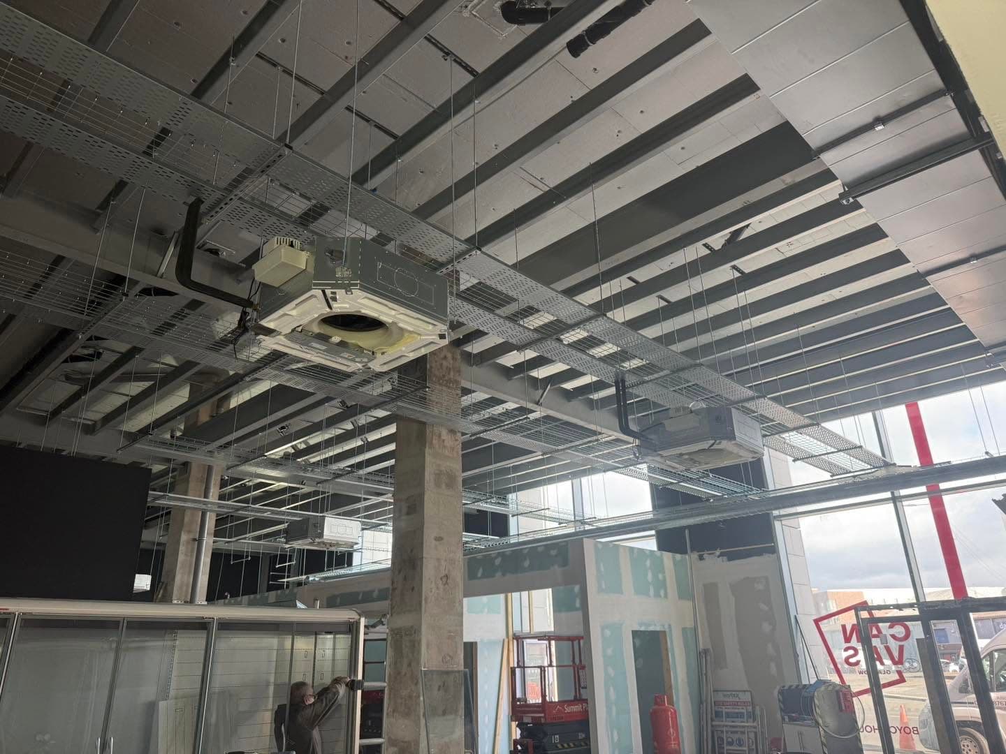Suspended ceiling grid with cable containment and air conditioning units fitted during a commercial unit fit-out